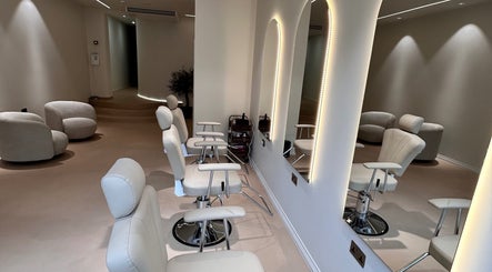 Chic interior of GB BROWS in London, England, GB with modern white chairs and illuminated mirrors.