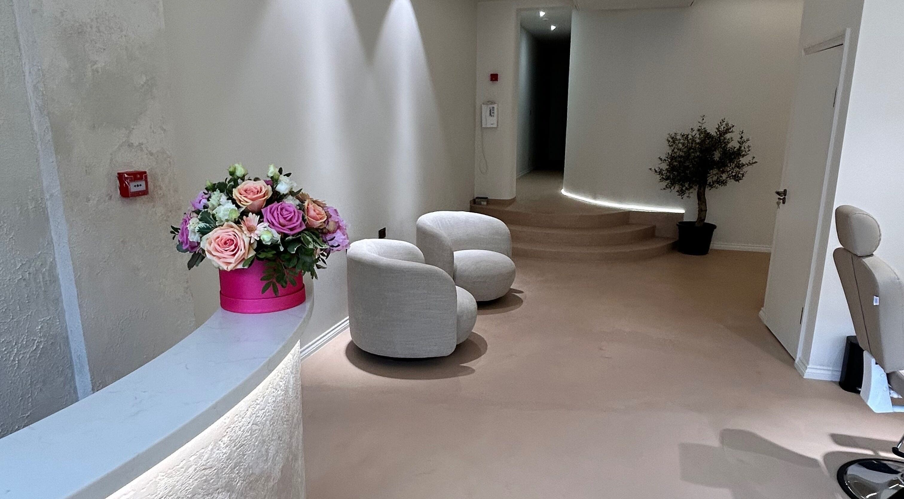 Elegant reception area at Gb Brows, featuring flower arrangement and plush seating in London, England, GB.