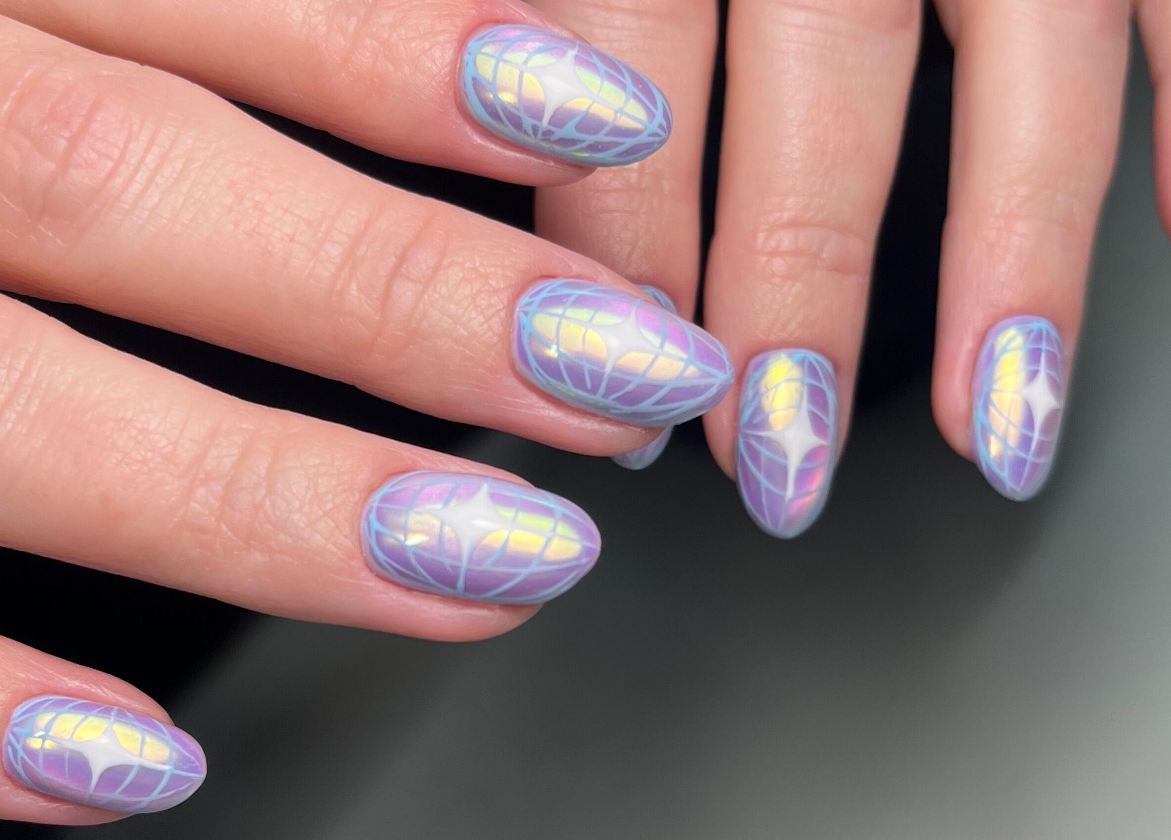Iridescent nail art at Dainty Daggers Salon, Calgary, Alberta, CA showcases intricate design and pastel hues.