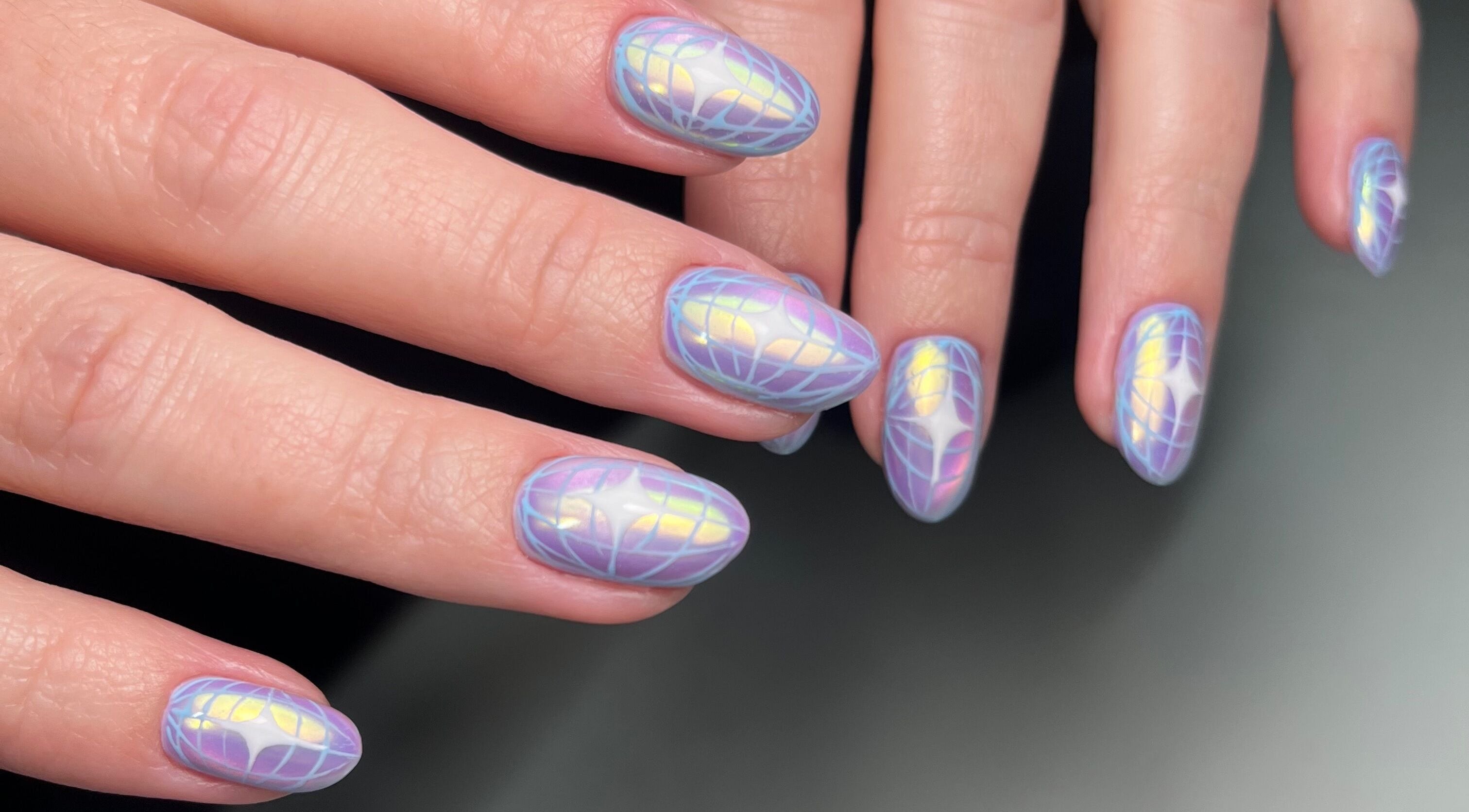 Iridescent nail art at Dainty Daggers Salon, Calgary, Alberta, CA showcases intricate design and pastel hues.