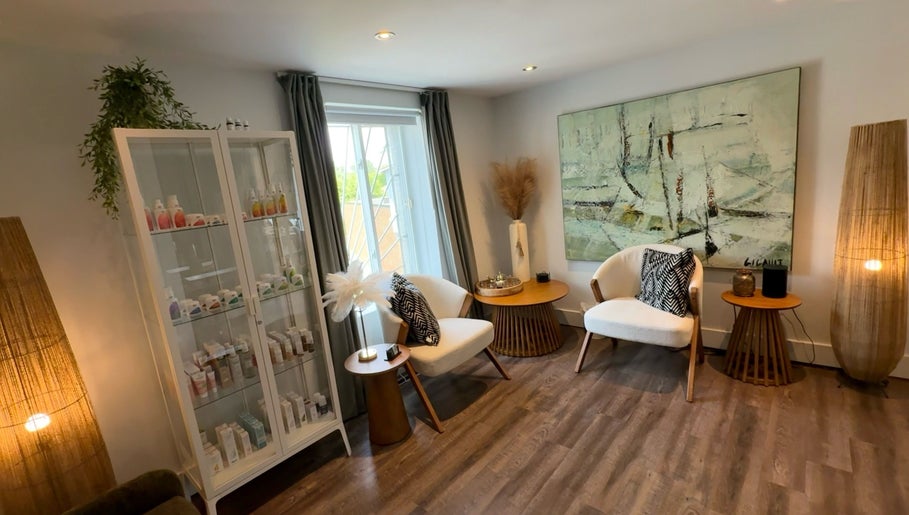 Intérieur élégant du salon DĒLUMI à Mirabel, Canada, CA avec fauteuils blancs et décoration moderne.