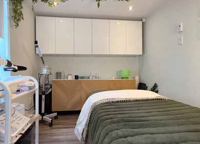 Salle de soins moderne chez DĒLUMI à Mirabel, Canada, CA, avec équipements et table de massage.