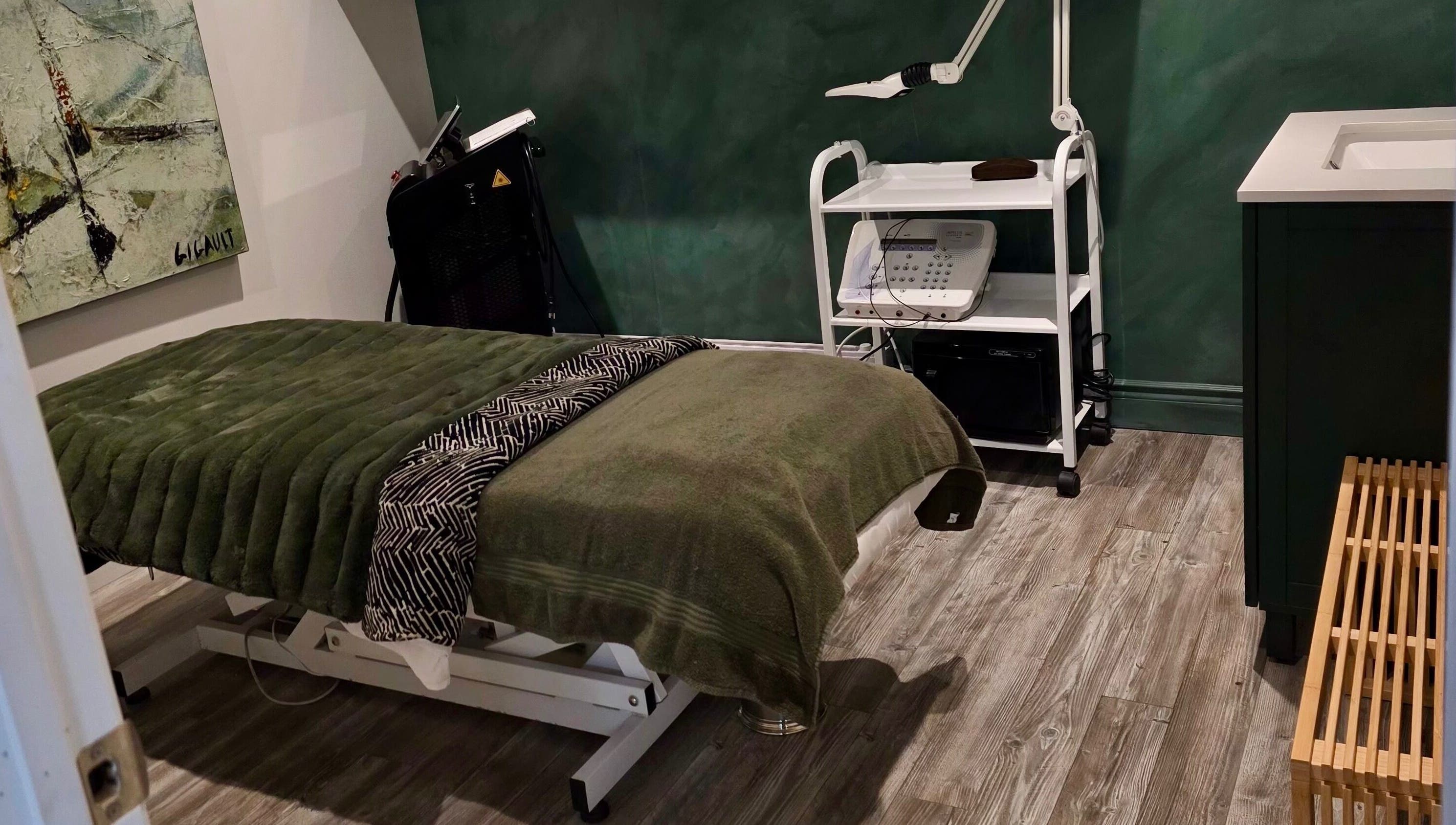 Salle de soins DĒLUMI à Mirabel, Canada, CA, avec table de massage et équipement esthétique.