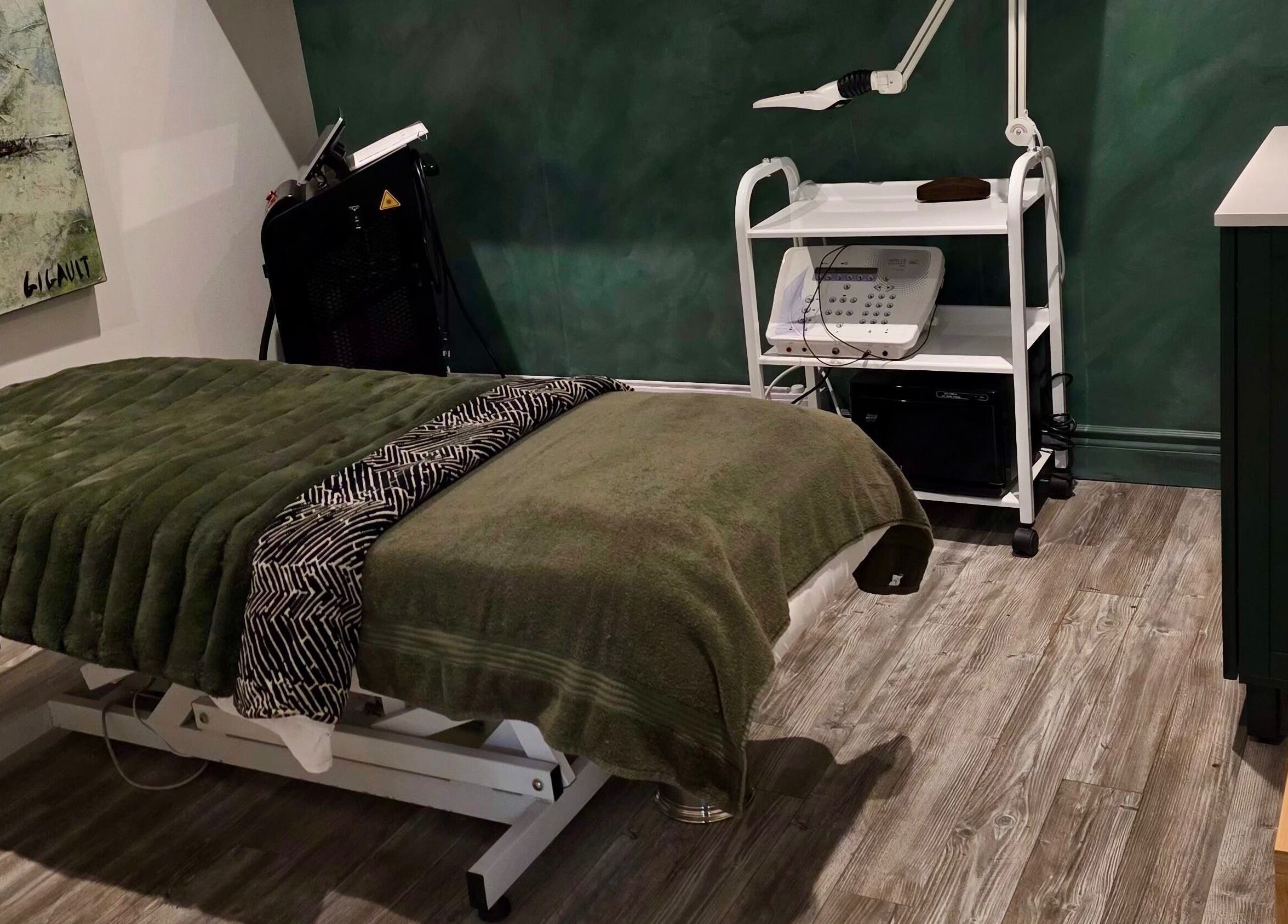 Salle de soins DĒLUMI à Mirabel, Canada, CA, avec table de massage et équipement esthétique.