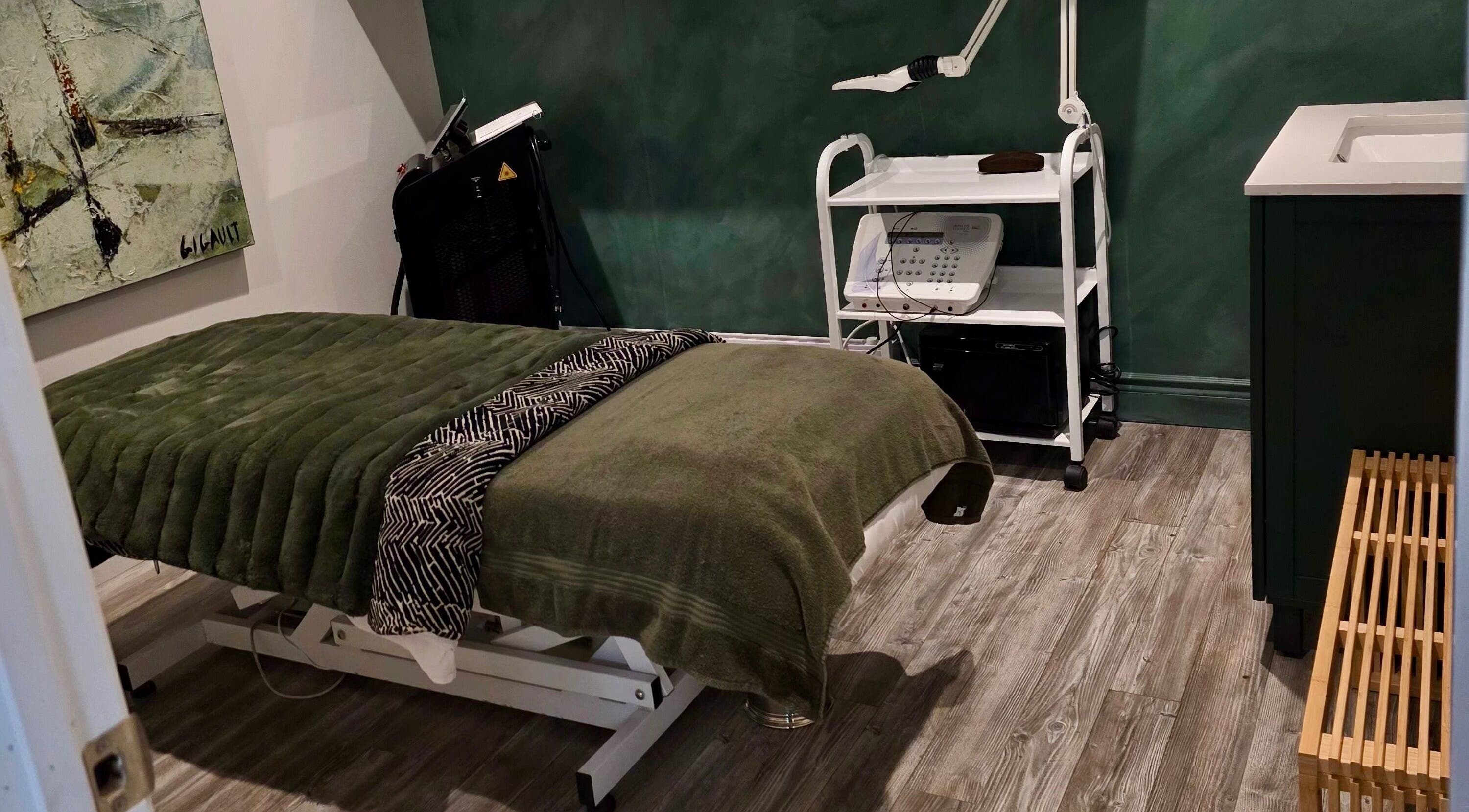 Salle de soins DĒLUMI à Mirabel, Canada, CA, avec table de massage et équipement esthétique.