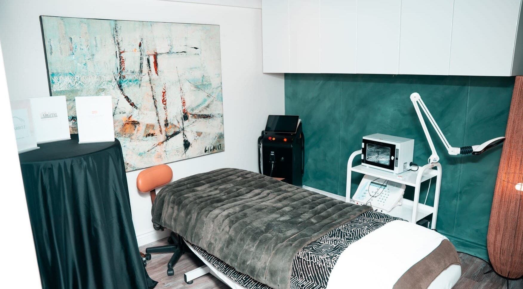 Salle de soins chic à DĒLUMI, Mirabel, Canada, CA avec lit de massage confortable et décoration artistique.