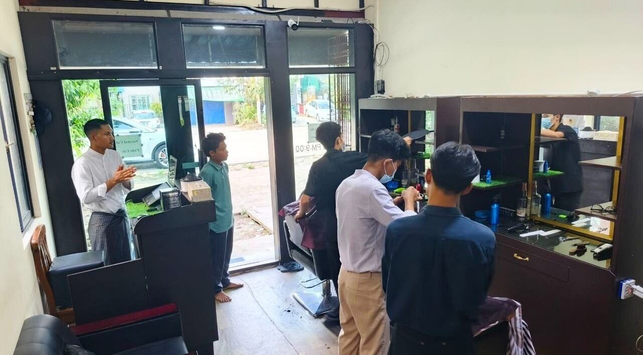Point (north dagon) salon interior in Yangon, showing clients receiving haircuts and vibrant decor.