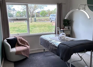 Calming therapy room at Wild River Beauty in Walcha, New South Wales, AU with massage table and cozy chair.