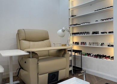Elegant nail care station at Diva beauty shop, Riyadh, Riyadh Province, SA, featuring a plush chair and product display.