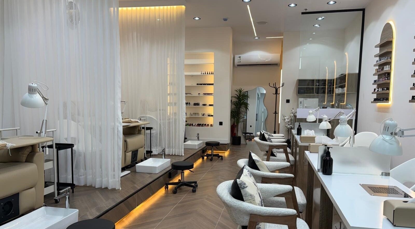 Luxurious interior of Diva Beauty Shop in Riyadh, Riyadh Province, SA with elegant nail stations and ambient lighting.