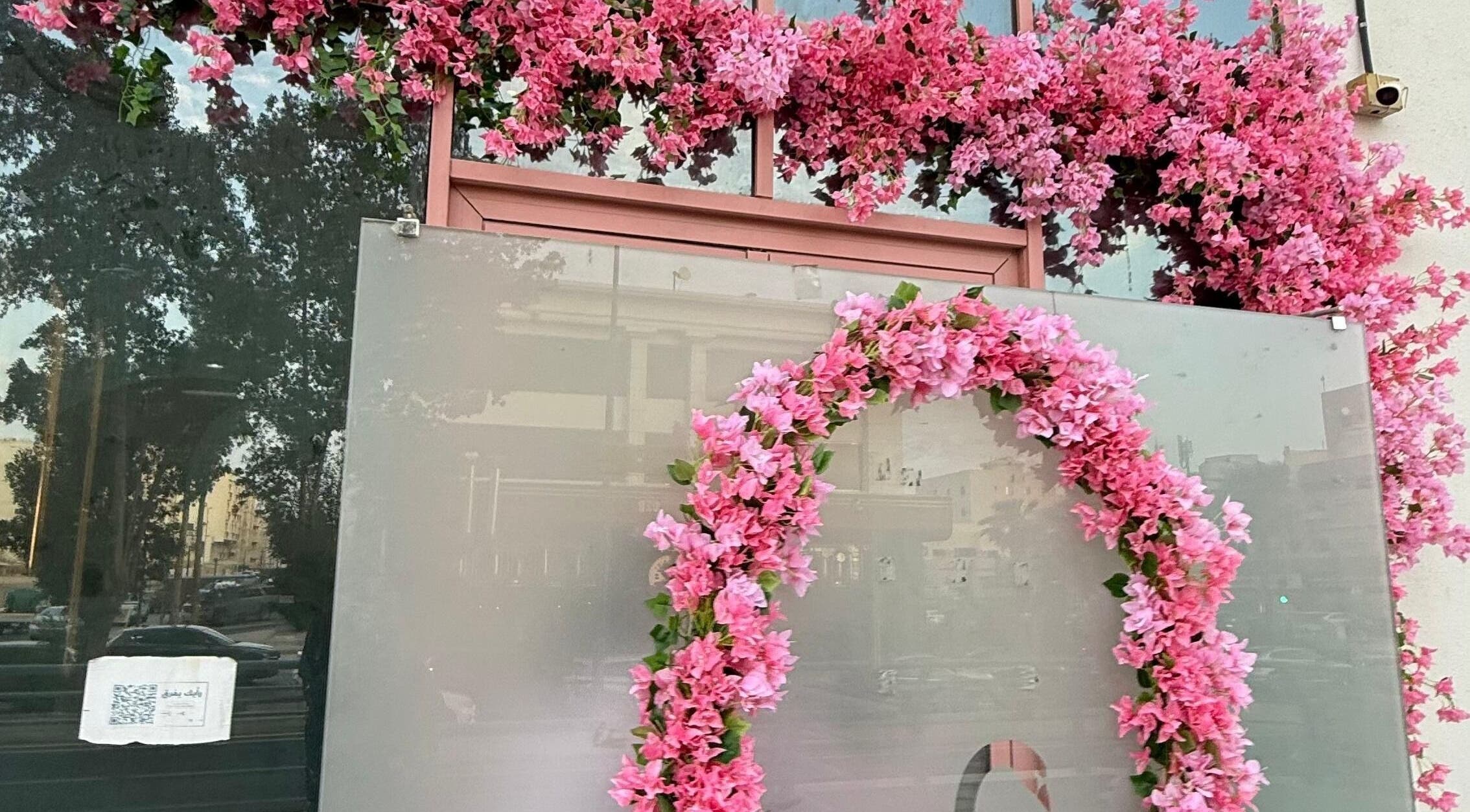 واجهة مزينة بزهور وردية في White Swan Salon، جدة، المملكة العربية السعودية.