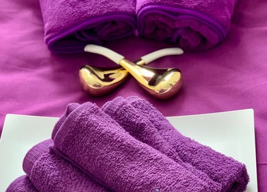 Plush purple towels and gold massage tools at Ur Beauty Oasis, Royal Tunbridge Wells, England, GB.