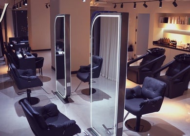 Chic interior of M hair and beauty at لوسيل, بلدية الضعاين, QA featuring modern salon chairs and styling stations.