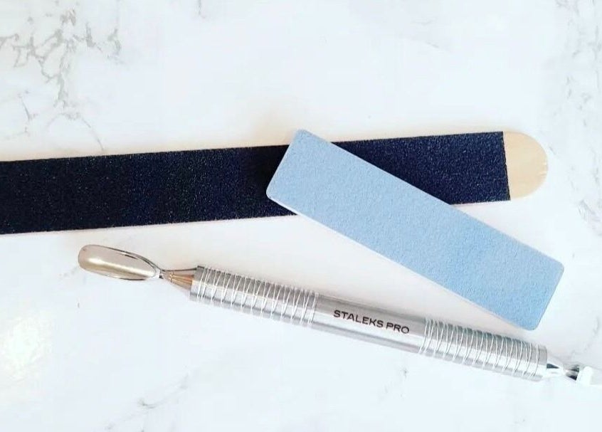 Professional nail tools at By Elisa H at Gosh Gosh PMU Clinic, London, England, GB on a marble surface.