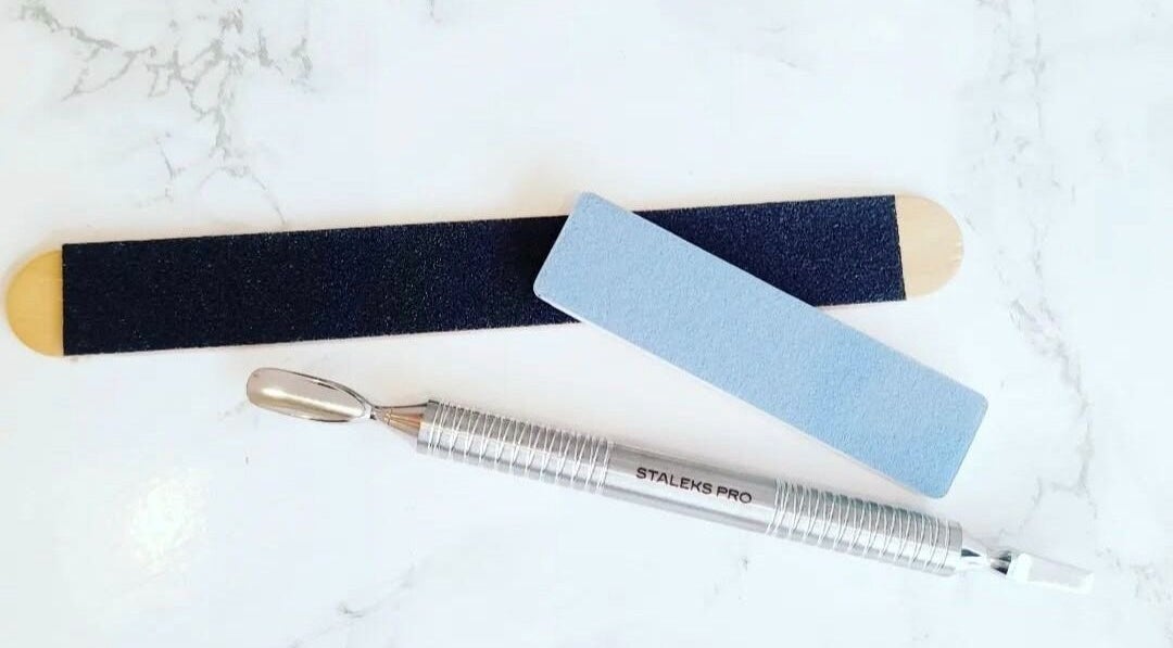 Professional nail tools at By Elisa H at Gosh Gosh PMU Clinic, London, England, GB on a marble surface.