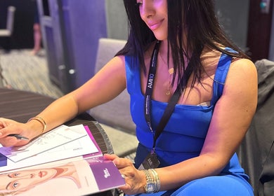 A woman in blue dress planning treatments at Routine Contour Clinic- Women Only, Melbourne, Victoria, AU.