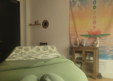 Calming decor at Playground For The Soul, Winston-Salem, North Carolina, US, featuring a massage table and serene tapestry.