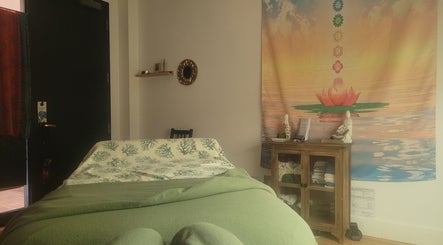 Calming decor at Playground For The Soul, Winston-Salem, North Carolina, US, featuring a massage table and serene tapestry.