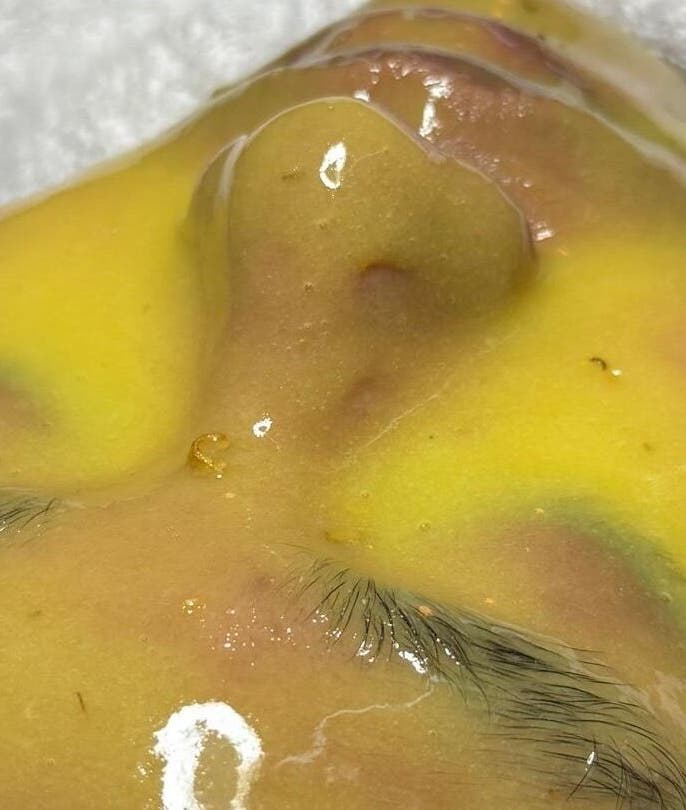 Luxurious facial treatment at Rainoura by Nurain Firdaus, Rawang, Selangor, MY, showcasing a vibrant yellow mask.