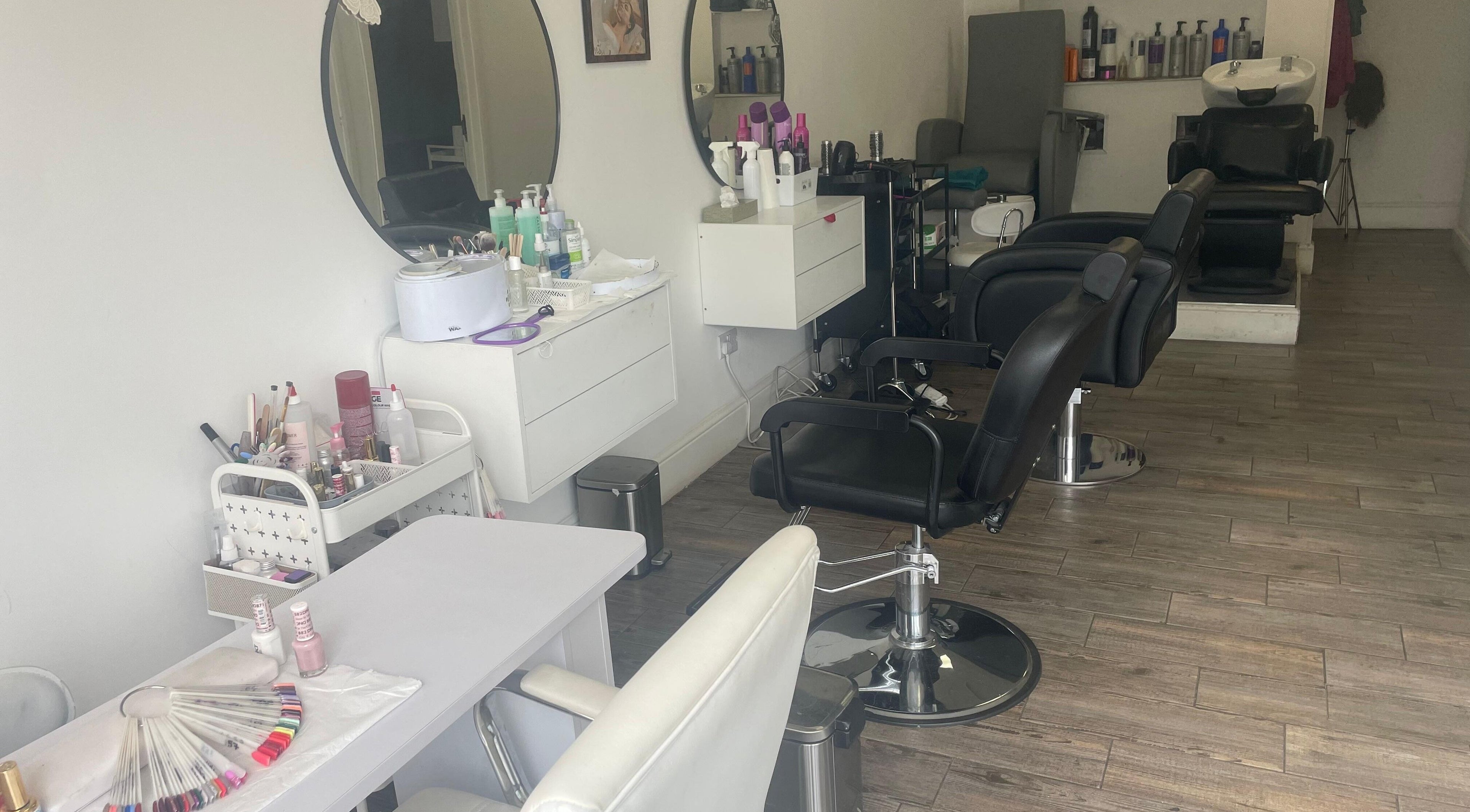 Modern salon setup at Strands Salon, Staines-upon-thames, England, GB, showcasing stylish chairs and beauty products.
