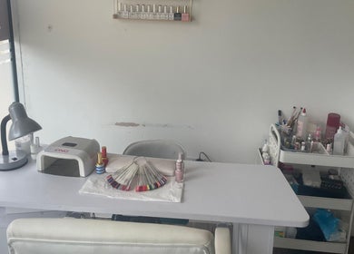 Nail salon workspace at Strands Salon in Staines-upon-Thames, England, GB, featuring manicure tools and polish.