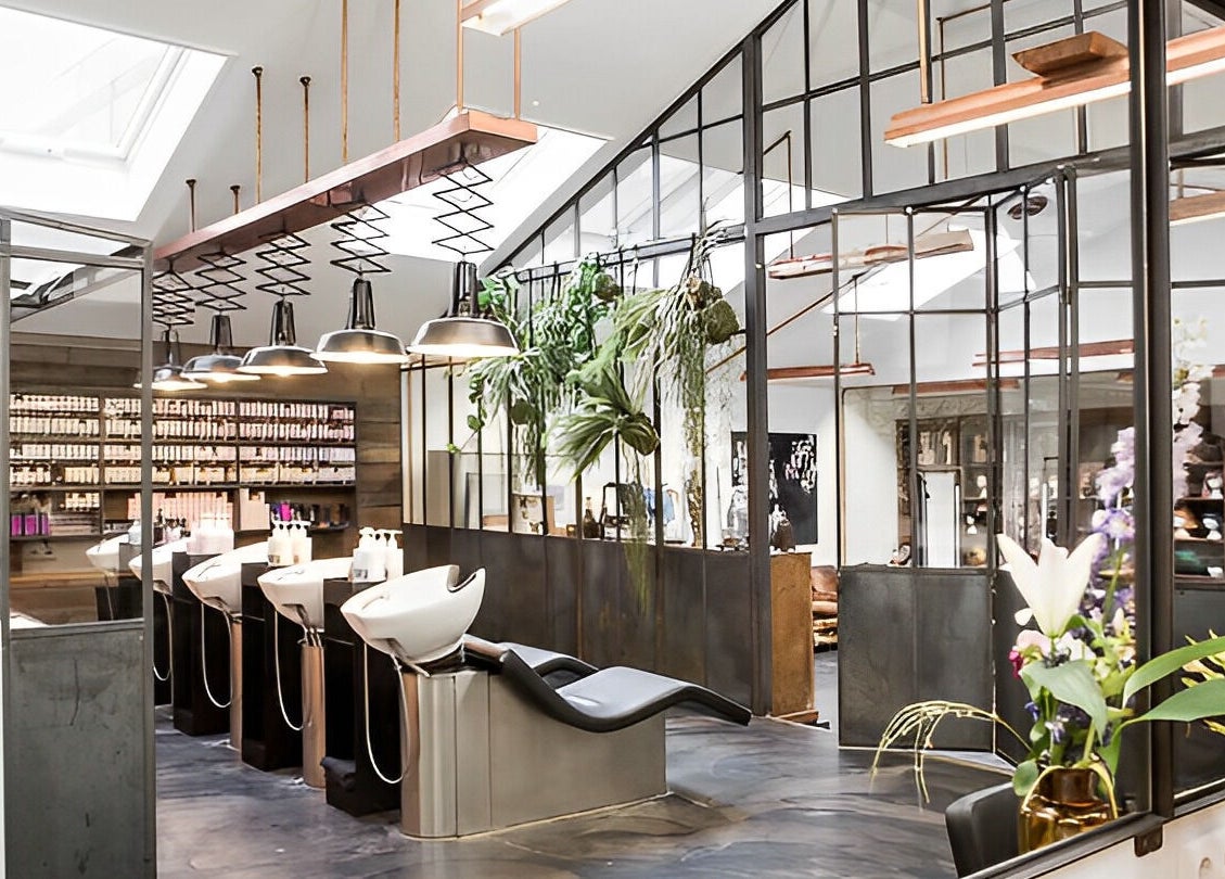 Sophisticated salon interior at Mogeen with styling chairs, plants, and modern design in Amsterdam, Noord-Holland, NL.