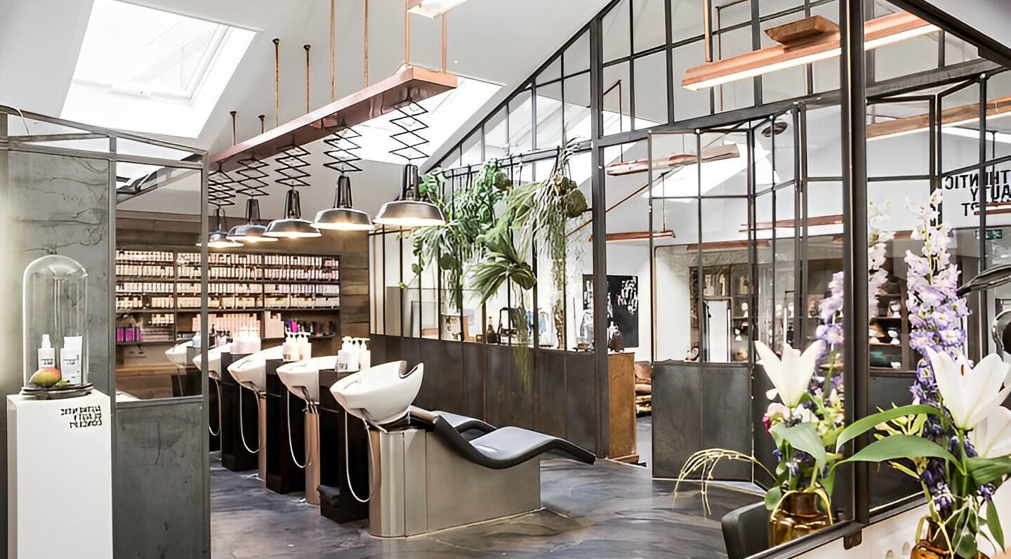 Sophisticated salon interior at Mogeen with styling chairs, plants, and modern design in Amsterdam, Noord-Holland, NL.