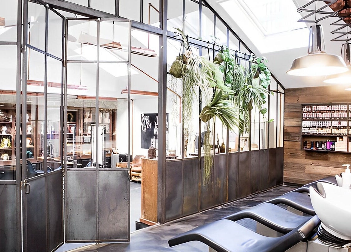 Stylish interior of Mogeen salon, Amsterdam, Noord-Holland, NL, showcasing modern decor and lush greenery.