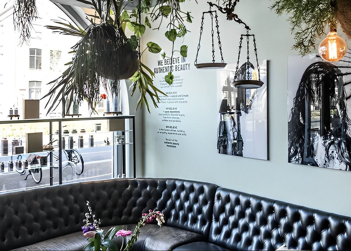 Modern lounge area at Mogeen in Amsterdam, Noord-Holland, NL, with stylish decor and greenery.