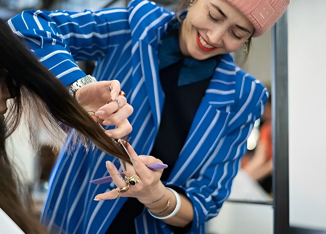 Stylist giving a haircut at Mogeen in Amsterdam, Noord-Holland, NL, showcasing professional beauty services.