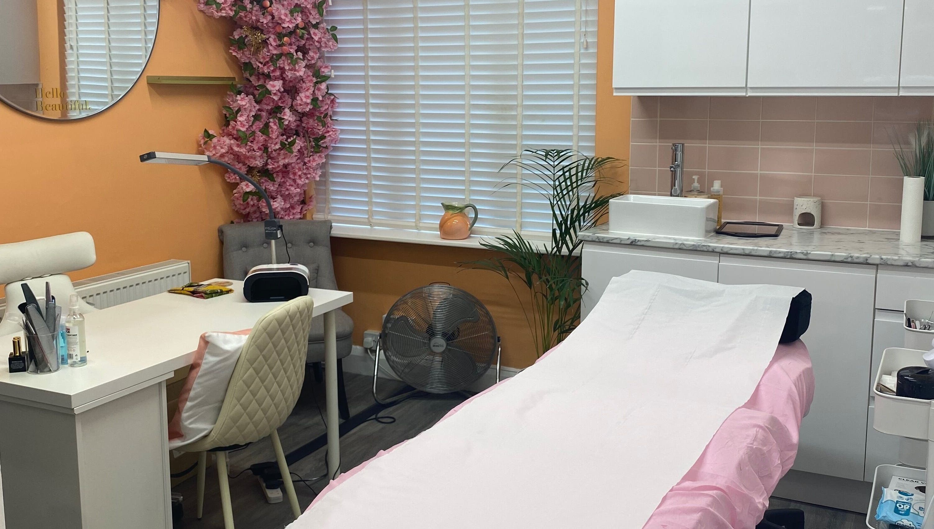 Inside Peaches Beauty Studio, Nottingham, England, GB, showcasing a serene treatment room with pink accents.