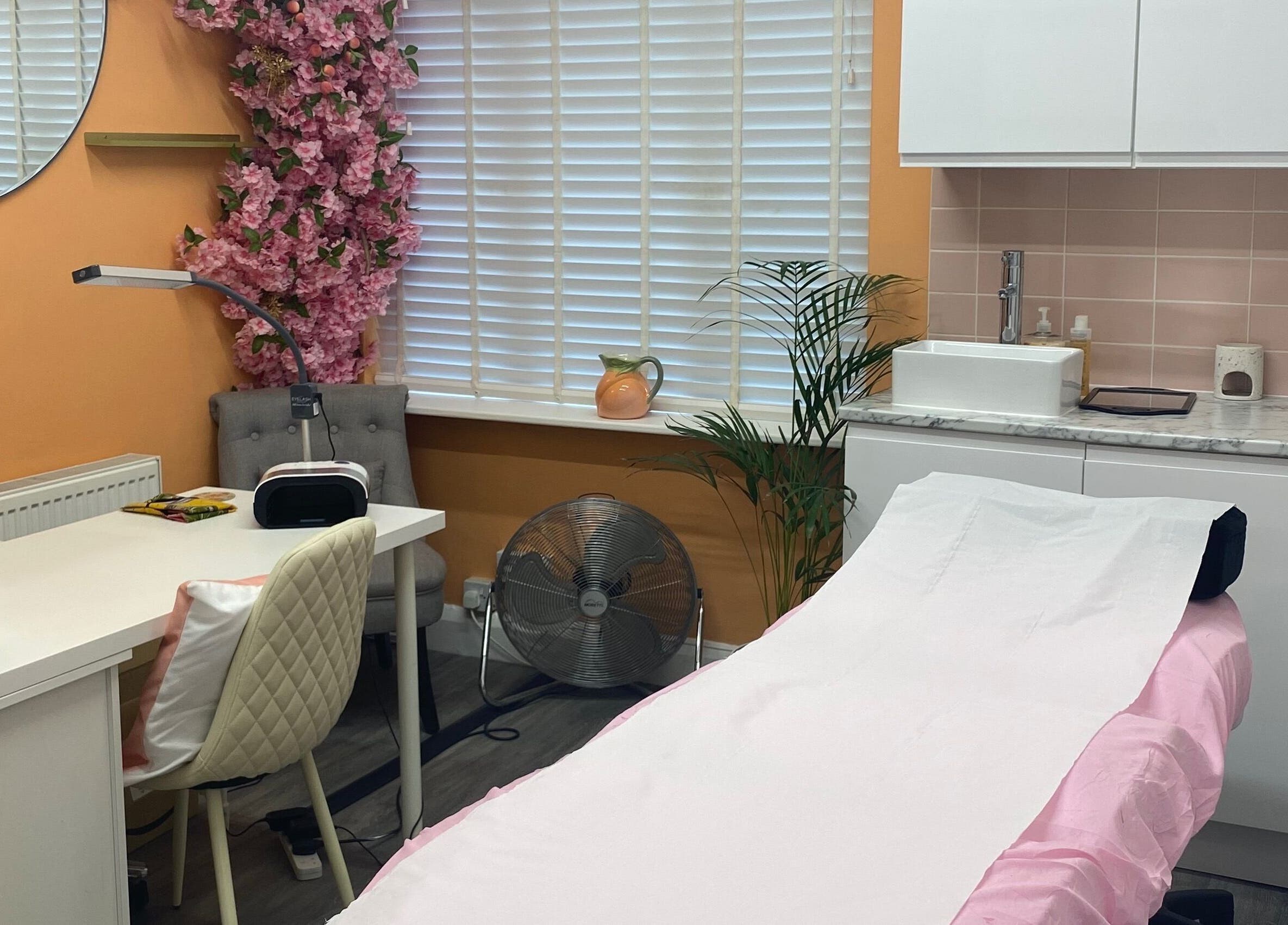 Inside Peaches Beauty Studio, Nottingham, England, GB, showcasing a serene treatment room with pink accents.