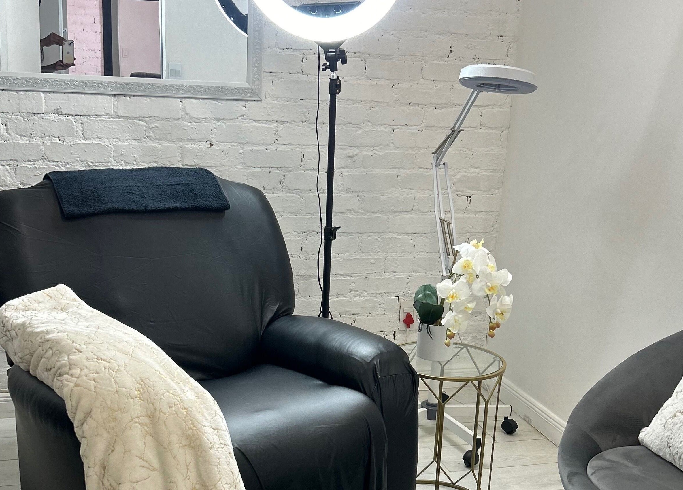 Relaxing seating area at Shugarlashpro | Central Square, Sandton, Gauteng, ZA, featuring cozy decor and a light.