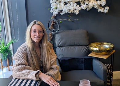Woman relaxing at Beauty by blue, Farsley, England, GB, beside a gold bowl and greenery.