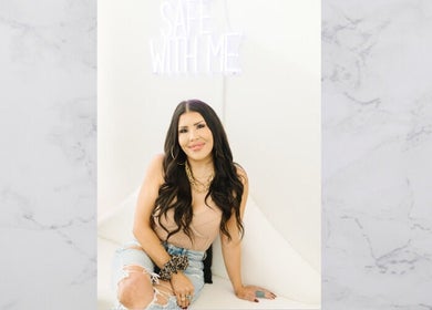 Woman smiling at The OG Brazilianaire Studio, Spanish Fork, Utah, US, under 'Safe With Me' sign.