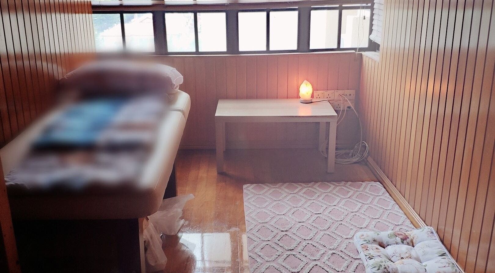 Cozy treatment room at soul2skinstudio, Slough, England, GB with a lit salt lamp and cushioned floor mat.
