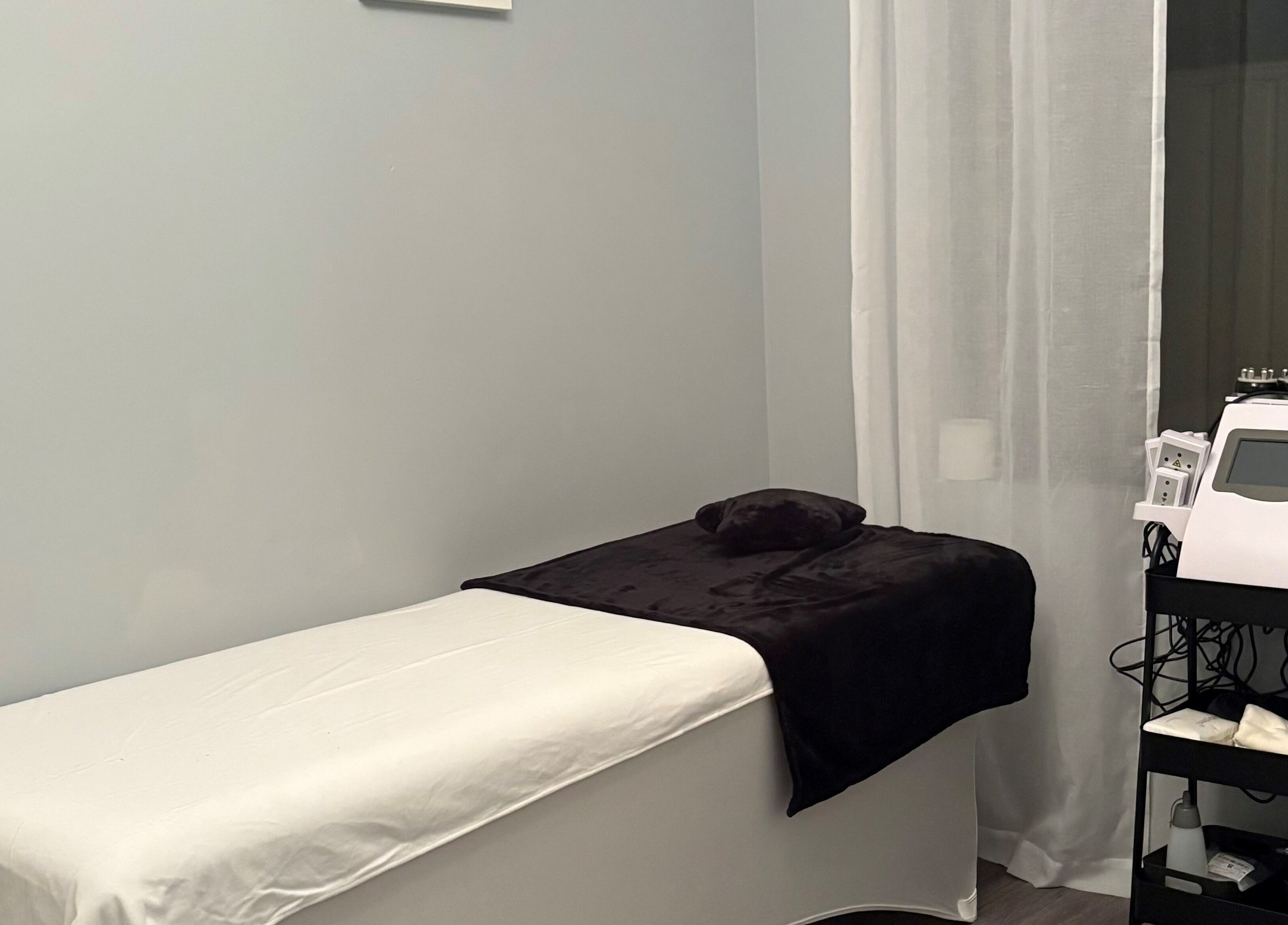 Cozy treatment room at Sculpte Society, Warnbro, Western Australia, AU with bed and modern equipment.