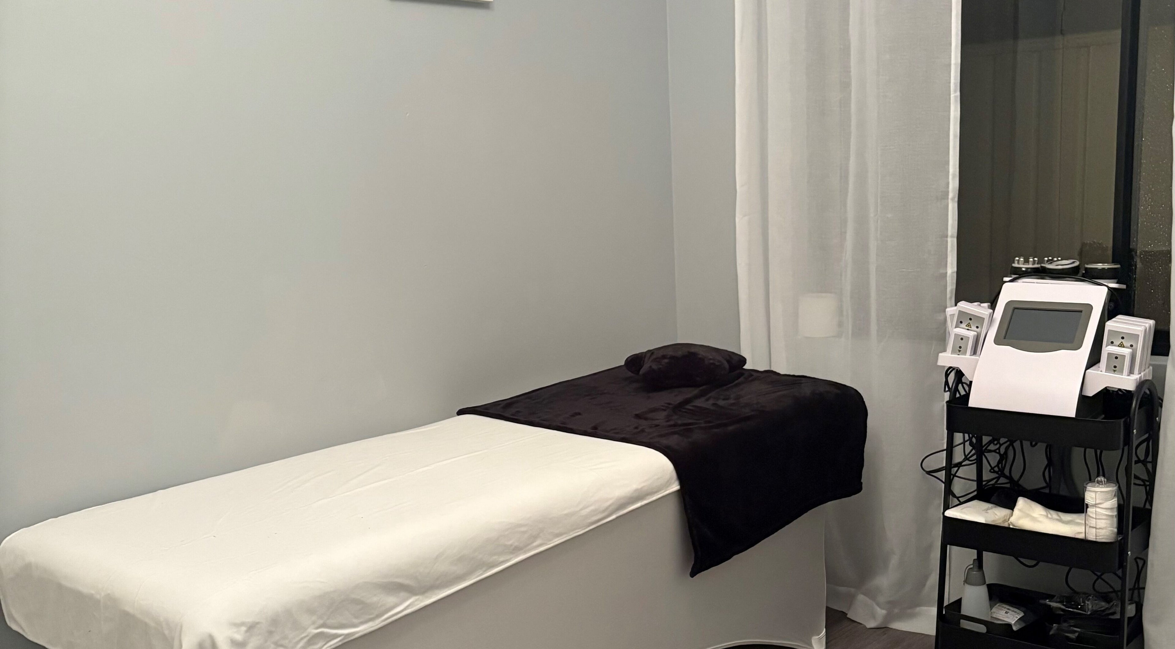 Cozy treatment room at Sculpte Society, Warnbro, Western Australia, AU with bed and modern equipment.