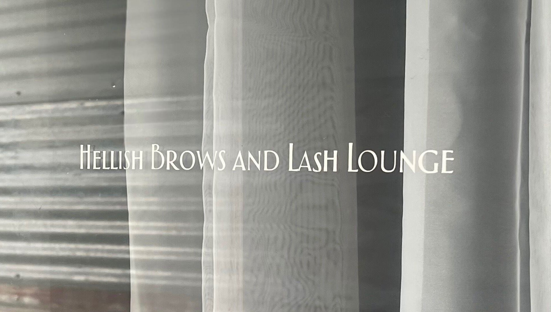 Entrance signage of Hellish Brows and Lash Lounge, Forest Hill, Queensland, AU on glass door.