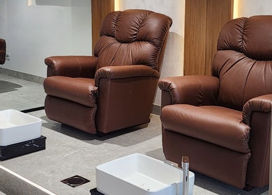Luxurious brown pedicure chairs at The Good Man, Dubai, Dubai, AE offering comfort and style.