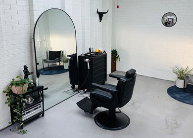 Stylish salon chair and mirror at Ash Bang, Melbourne, Victoria, AU with modern decor and greenery.