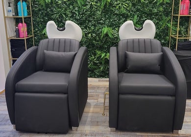 Luxurious salon chairs at Reflection Hair and Beauty Norwich, Norwich, England, GB, with a green foliage backdrop.