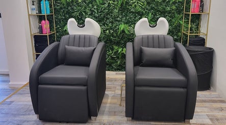 Luxurious salon chairs at Reflection Hair and Beauty Norwich, Norwich, England, GB, with a green foliage backdrop.