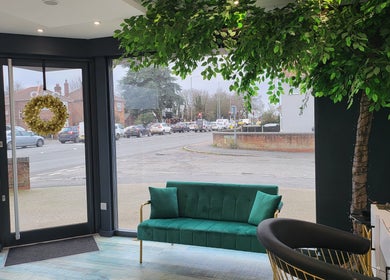 Inviting waiting area in Reflection Hair and Beauty Norwich, Norwich, England, GB with green sofa and nature decor.