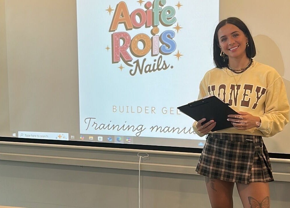 Workshop at Aoife Rois Nails, Newtownabbey with presenter, showcasing training manual on screen.