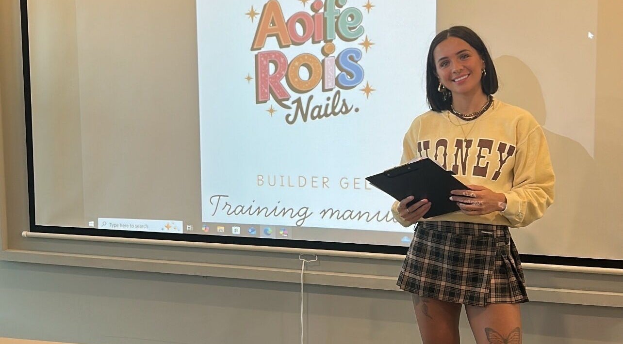 Workshop at Aoife Rois Nails, Newtownabbey with presenter, showcasing training manual on screen.