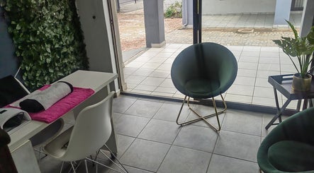Chic seating and manicure setup at Pruddy's Beauty Studio, Benoni, Gauteng, ZA, with lush greenery accent.