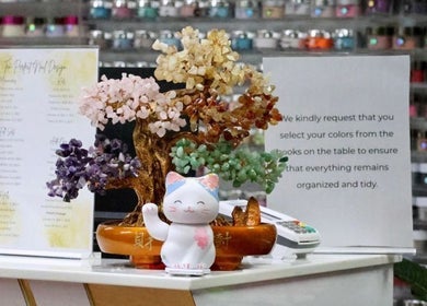 Charming decor at Ten Perfect Nail Design in Lowell, Massachusetts, US featuring a colorful gemstone tree and cat figurine.