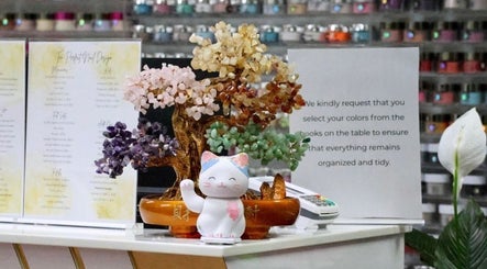 Charming decor at Ten Perfect Nail Design in Lowell, Massachusetts, US featuring a colorful gemstone tree and cat figurine.
