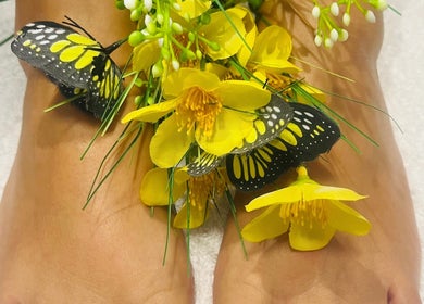 Pies decorados con flores amarillas y mariposas en Advanced Aesthetics VM, Villamartín, Comunidad Valenciana, ES.